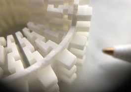 Fine polymer lattice detail beside a pen tip